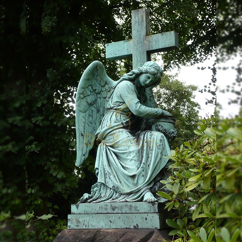 Female angel statue with cross used for outdoor grave decoration